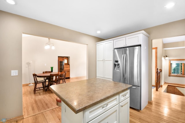 kitchen with a center island, stainless steel fridge with ice dispenser, recessed lighting, light wood-style flooring, and white cabinetry