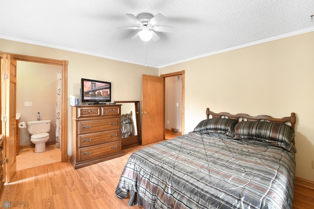 bedroom featuring a ceiling fan, light wood finished floors, ensuite bath, a textured ceiling, and crown molding