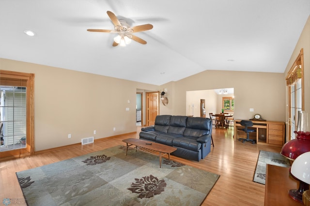 living room with visible vents, light wood finished floors, a healthy amount of sunlight, and vaulted ceiling