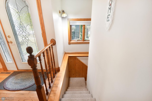 staircase featuring visible vents, baseboards, and wood finished floors