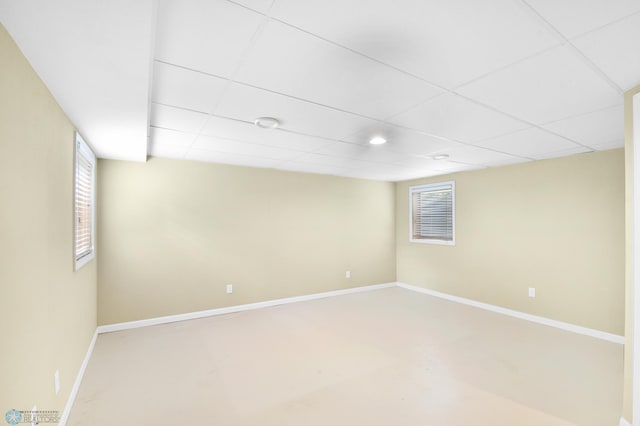 unfurnished room featuring baseboards and a drop ceiling