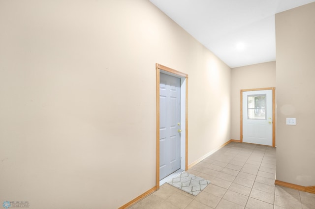 foyer entrance featuring light tile patterned floors and baseboards