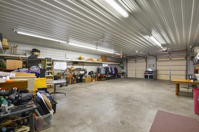 garage with a workshop area, a garage door opener, and metal wall