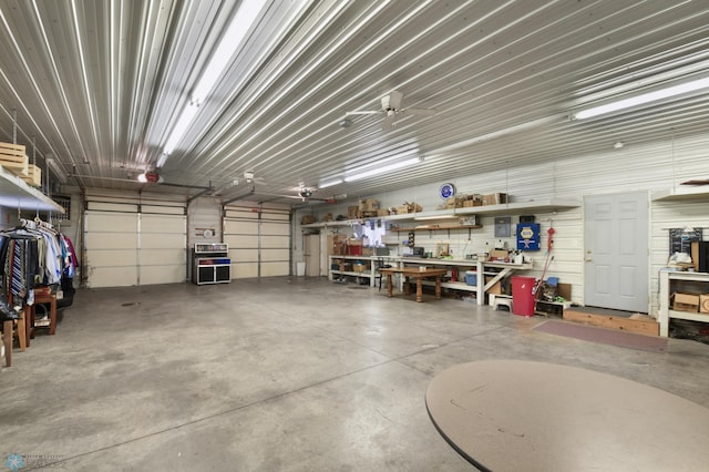 garage with a workshop area, a garage door opener, and metal wall