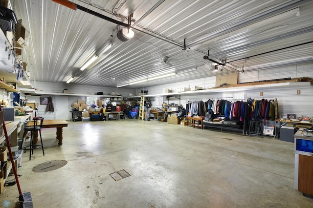 garage with a workshop area, a garage door opener, and metal wall