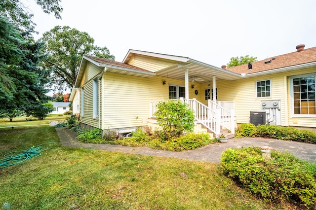 view of front of property with a front lawn and central AC