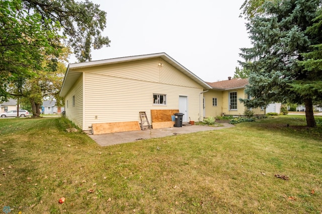 rear view of property featuring a patio and a yard