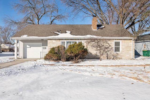 view of snowy exterior featuring an attached garage, stone siding, a chimney, and roof with shingles