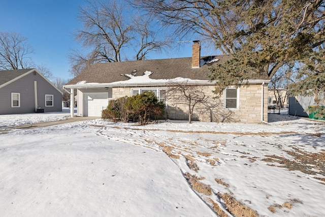 view of front of house with an attached garage, stone siding, and a chimney