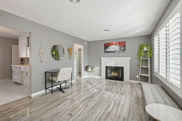 living room with a brick fireplace, visible vents, plenty of natural light, and baseboards