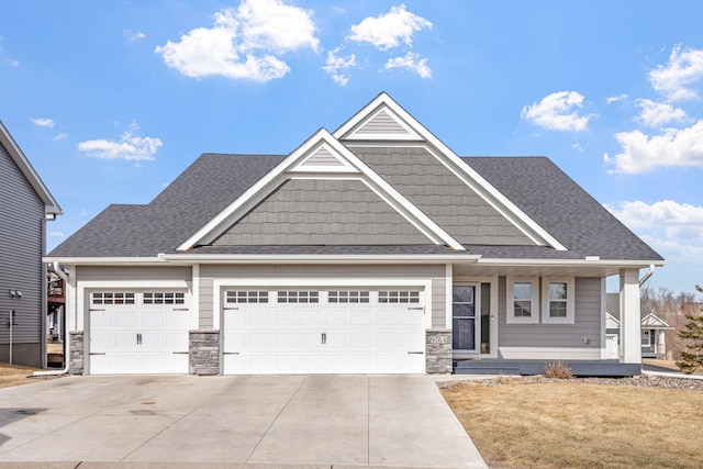 craftsman-style house featuring a garage, concrete driveway, stone siding, roof with shingles, and a front lawn