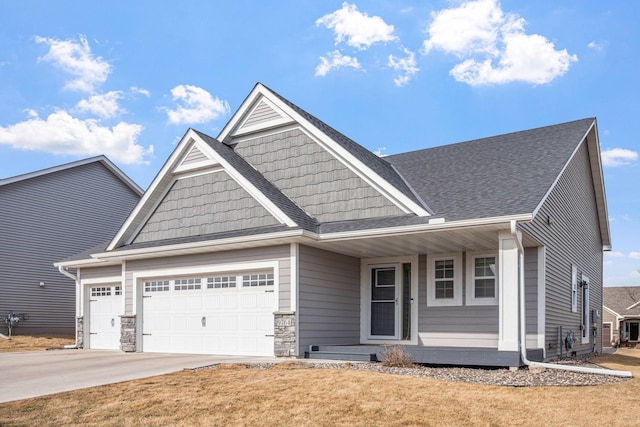 craftsman house with a garage, a shingled roof, concrete driveway, stone siding, and a front lawn