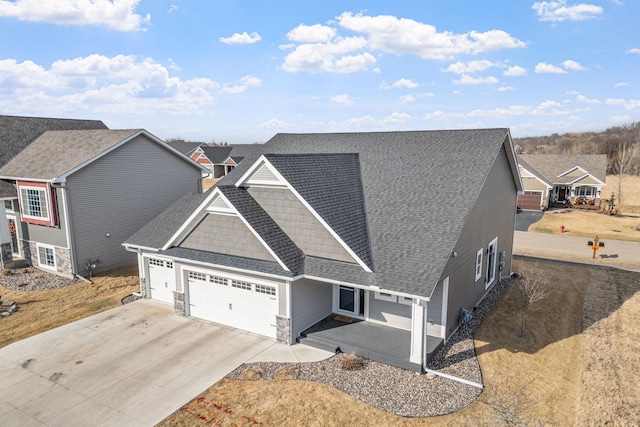 view of front facade featuring a shingled roof, concrete driveway, and an attached garage