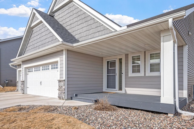 9764 Saint Andrews Dr, Elko New Market, MN 55020 - entrance to property featuring concrete driveway, an attached garage, covered porch, stone siding, and a shingled roof