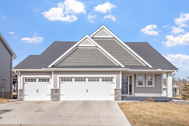 9764 Saint Andrews Dr, Elko New Market, MN 55020 - view of front of house with an attached garage, concrete driveway, stone siding, covered porch, and a shingled roof