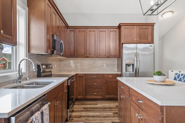 9764 Saint Andrews Dr, Elko New Market, MN 55020 - kitchen with stainless steel appliances, dark wood-type flooring, a sink, backsplash, and a center island