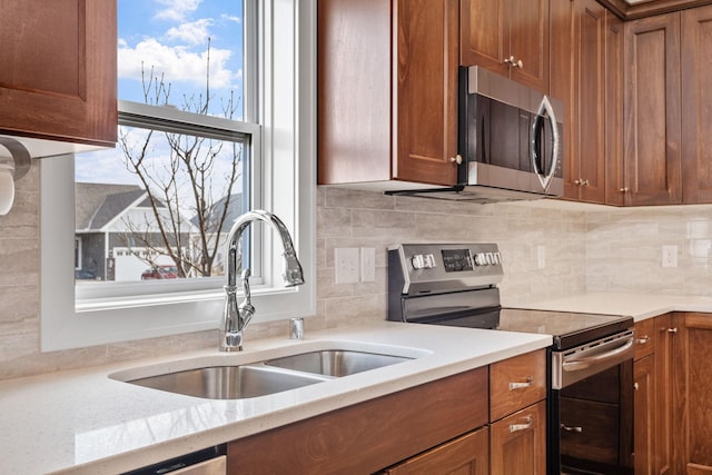 9764 Saint Andrews Dr, Elko New Market, MN 55020 - kitchen featuring appliances with stainless steel finishes, a sink, and brown cabinetry