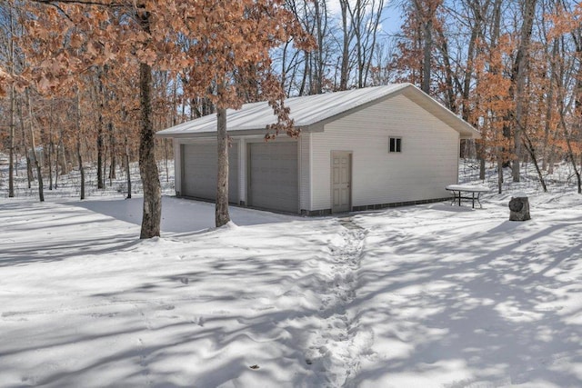 snow covered garage with a garage