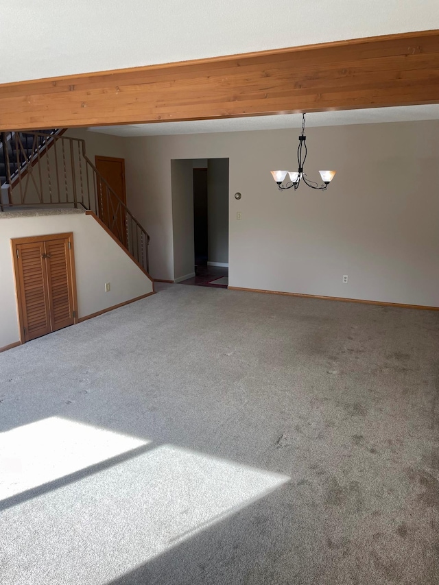 carpeted empty room featuring stairs, baseboards, beam ceiling, and a notable chandelier