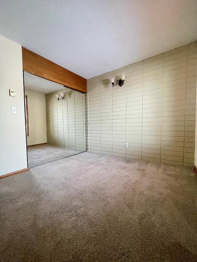 carpeted spare room featuring a textured ceiling