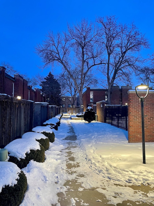 yard layered in snow featuring fence