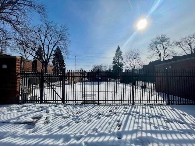 snow covered gate featuring fence