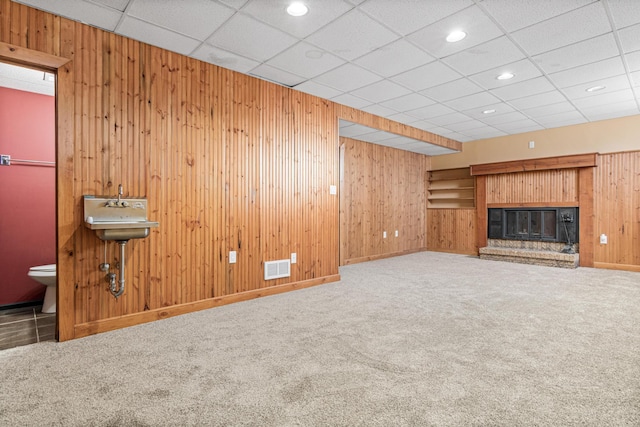 3879 Polk St NE, Columbia Heights, MN 55421 - unfurnished living room with visible vents, wood walls, carpet flooring, and a sink