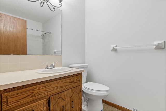 3879 Polk St NE, Columbia Heights, MN 55421 - bathroom featuring tasteful backsplash, a shower, baseboards, toilet, and vanity