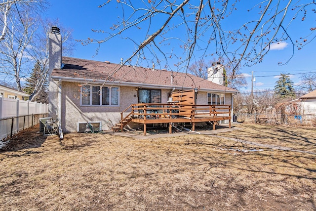3879 Polk St NE, Columbia Heights, MN 55421 - rear view of house with stucco siding, a chimney, a wooden deck, and a fenced backyard