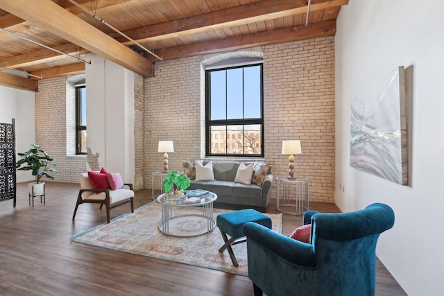 living room with a healthy amount of sunlight, brick wall, and wood finished floors