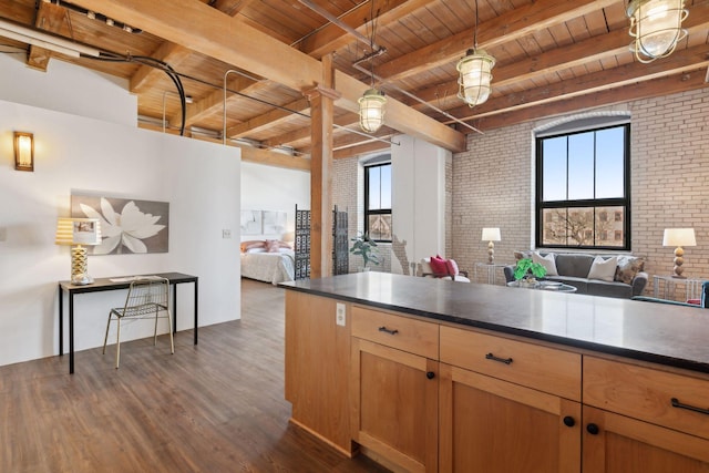 kitchen with open floor plan, a healthy amount of sunlight, and brick wall