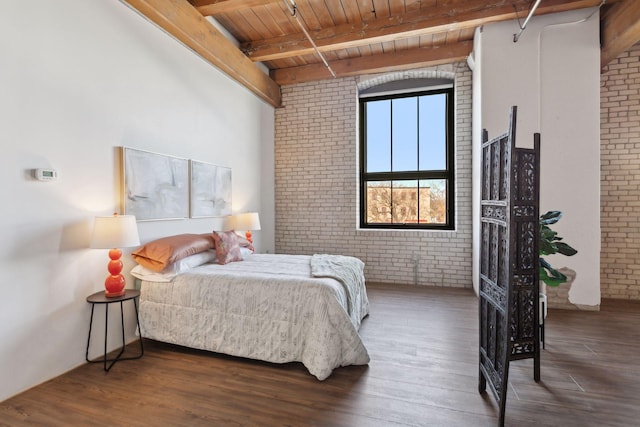 bedroom featuring wooden ceiling, beamed ceiling, brick wall, and wood finished floors