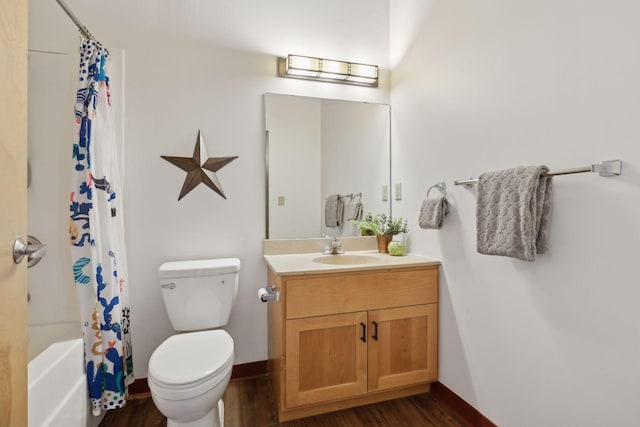 bathroom featuring baseboards, vanity, toilet, and wood finished floors