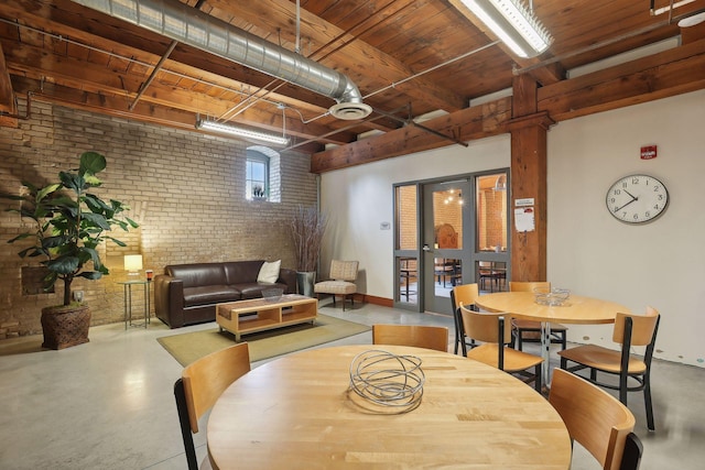 dining room with brick wall and finished concrete floors