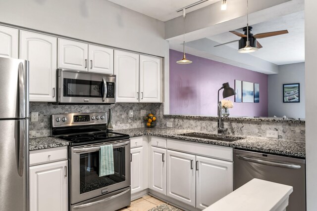 kitchen with white cabinets, backsplash, stainless steel appliances, and a sink