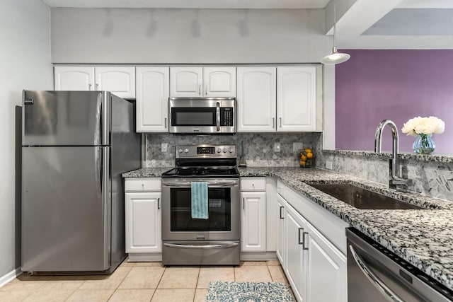 kitchen featuring stainless steel appliances, tasteful backsplash, a sink, and white cabinets