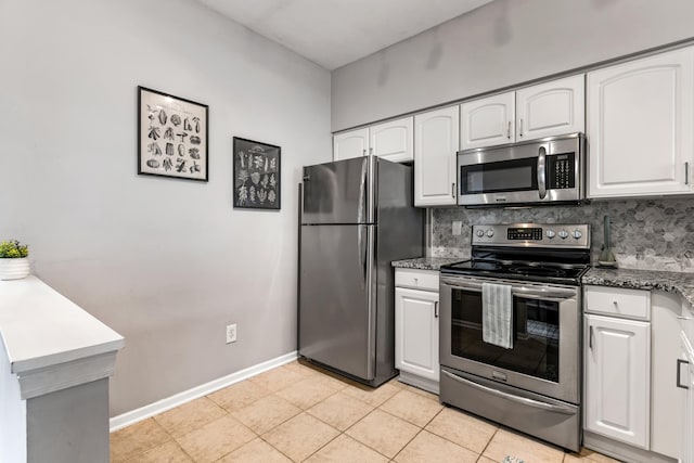 kitchen with appliances with stainless steel finishes, white cabinetry, and tasteful backsplash