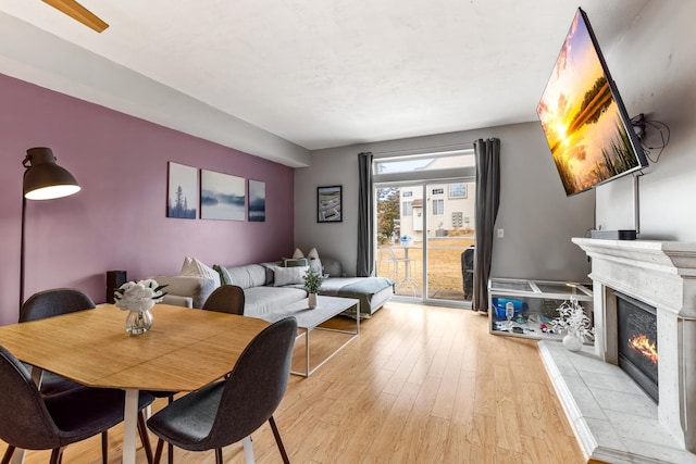 dining area featuring light wood-type flooring and a fireplace