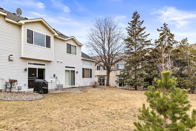 rear view of house with a lawn and a patio