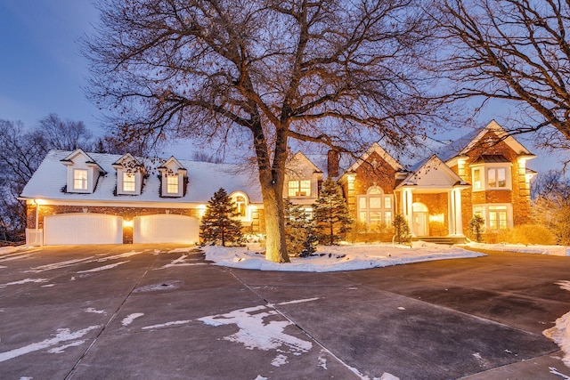 view of front of home featuring a garage, concrete driveway, and brick siding