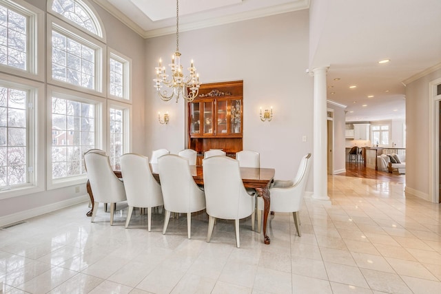 dining space with a high ceiling, baseboards, crown molding, and ornate columns