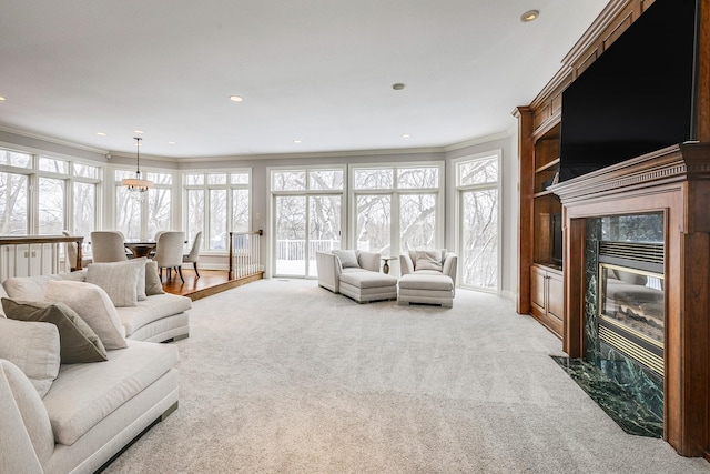 living area featuring ornamental molding, recessed lighting, light carpet, and a premium fireplace