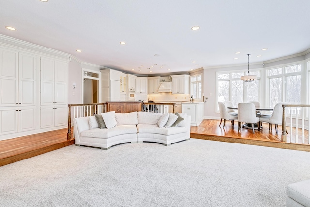 living room with light wood-style flooring, crown molding, and recessed lighting