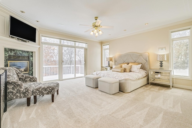 bedroom with ceiling fan, light colored carpet, a fireplace, access to exterior, and crown molding