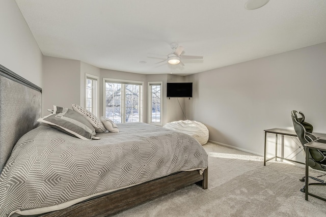 bedroom with light carpet, ceiling fan, and baseboards