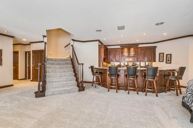 kitchen with a breakfast bar, light carpet, and baseboards