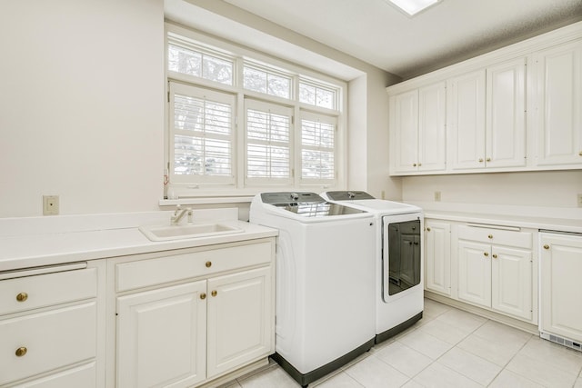 clothes washing area featuring washing machine and clothes dryer, light tile patterned flooring, a sink, and cabinet space