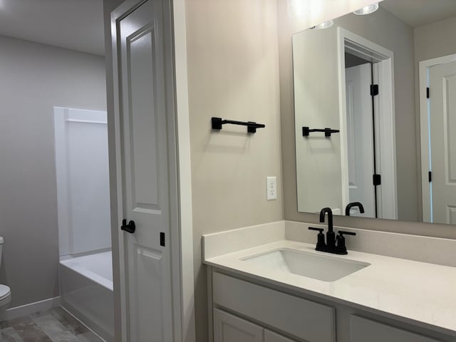 full bath with vanity, toilet, and a bath