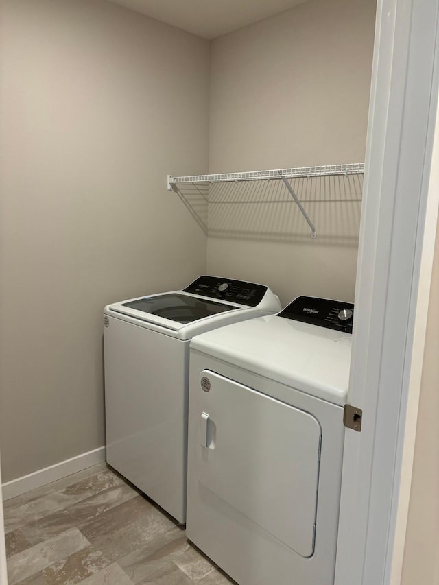 clothes washing area featuring laundry area, independent washer and dryer, and baseboards