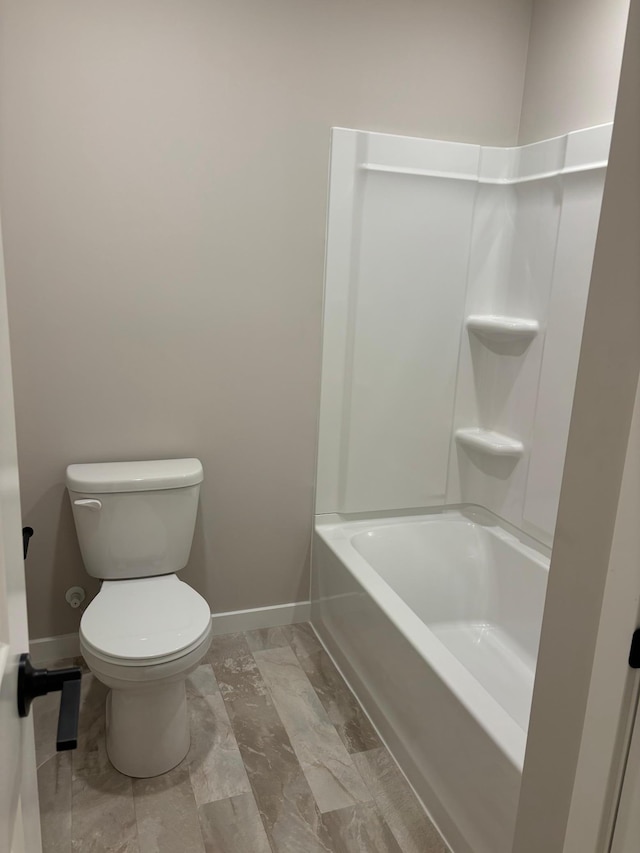 full bathroom with toilet and baseboards